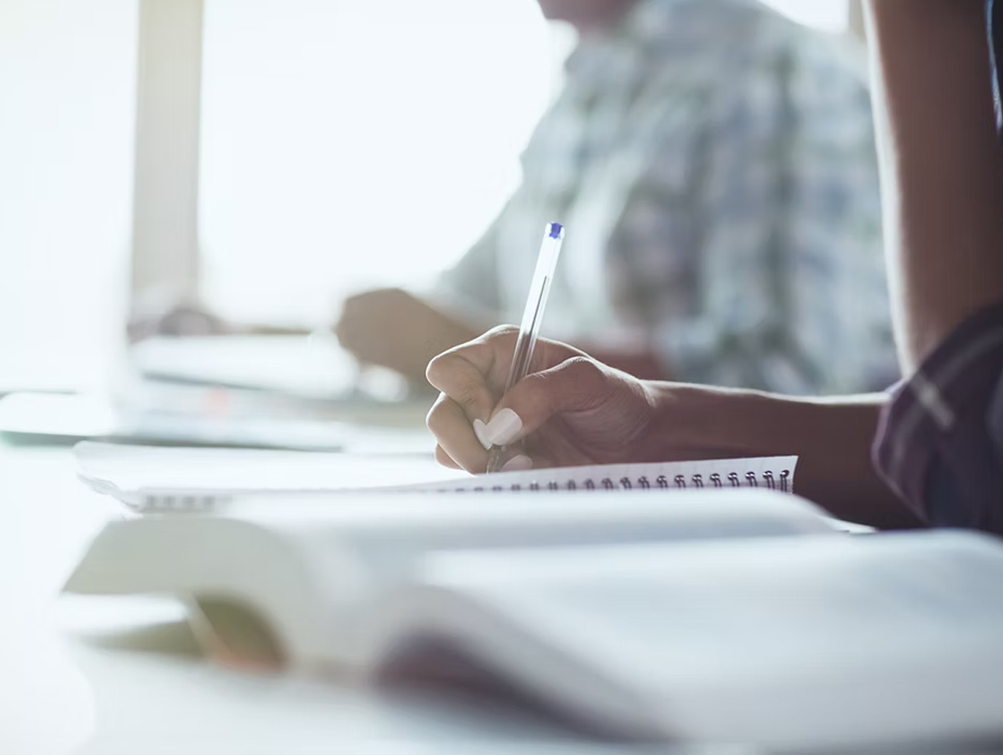 student writing in a notebook